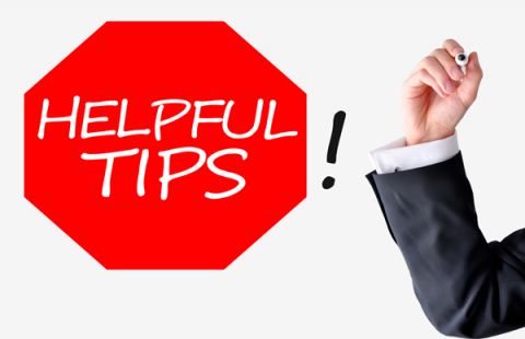 man's hand up right holding a marker as if to write on a board.  Stop sigh shaped (octagon) in red that reads Helpful Tips in white writing, a black exclamation mark to the right of the writing and shape.